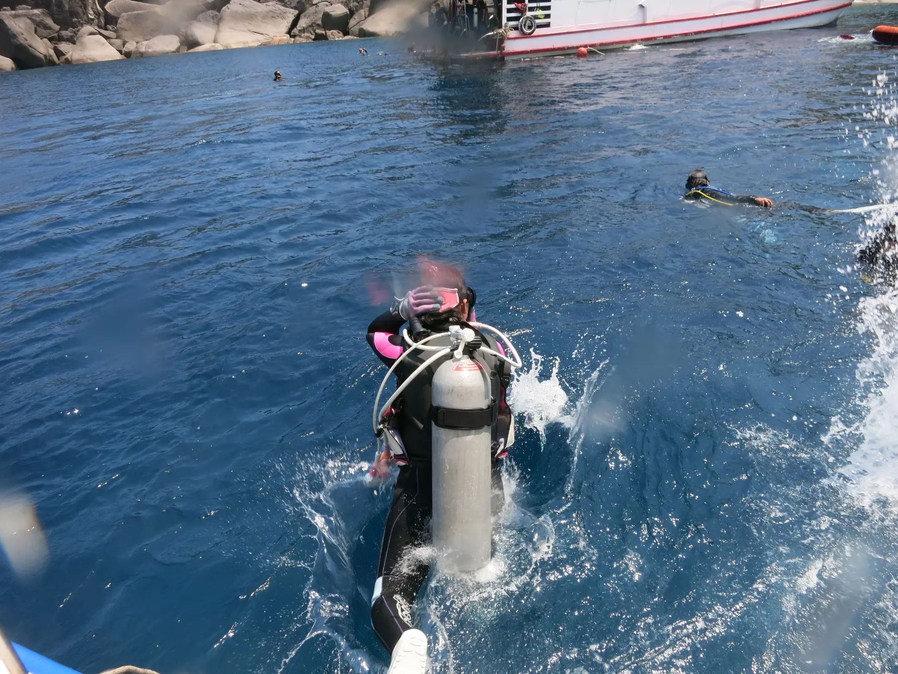 船から海へエントリーする女性ダイバー