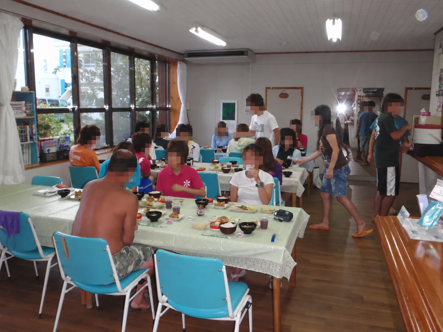 慶良間荘で大人数が食卓を囲む食事風景（学生の顔をモザイク処理済み）