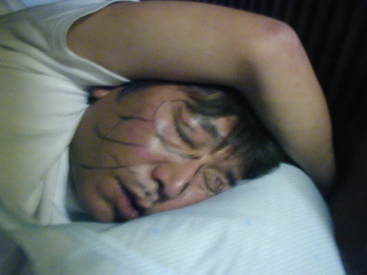 顔に落書きをされて眠る杜山氏